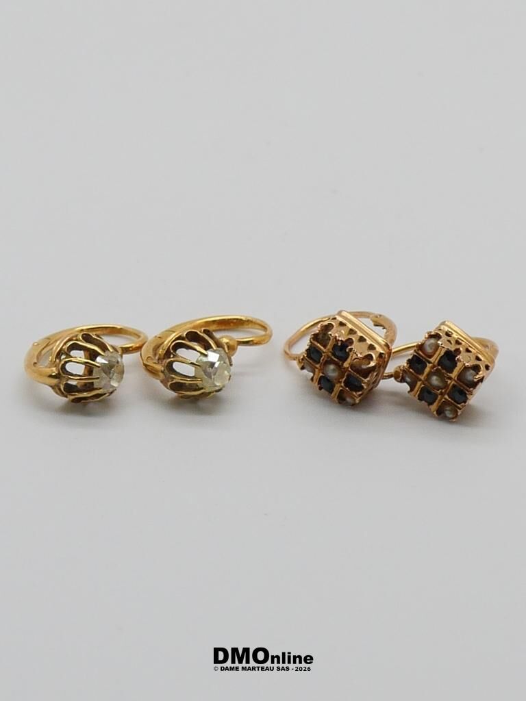Two gold rings with clear gems and two square stud earrings with dark stones on a white background mix of jewelry pieces.