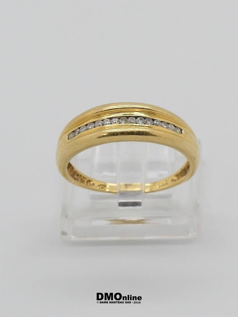 Gold ring with a row of diamonds along a central channel, displayed on a clear stand
