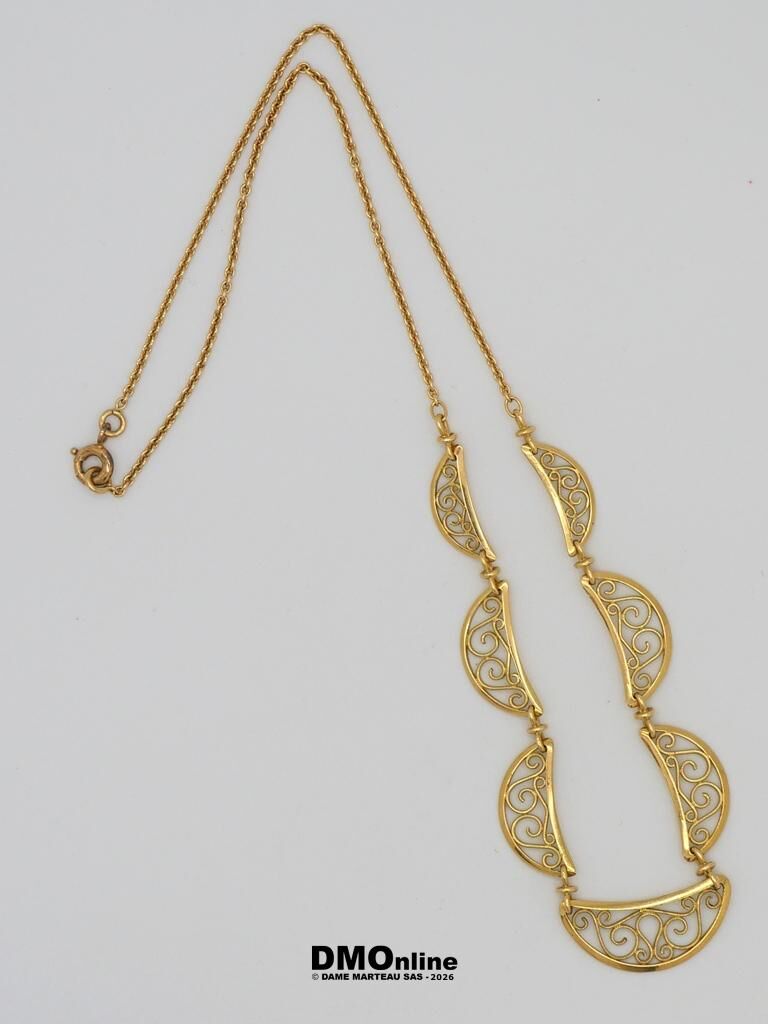 Gold necklace with decorative crescent filigree links connected along a chain and a curved pendant at the end.
